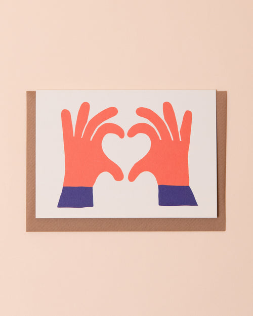 Greetings card with a hand making a heart shape