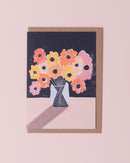 Luiza Holub illustration greetings card in black, yellow, pink and red with a brown kraft envelope . Bunch of flowers in a vase on a table.